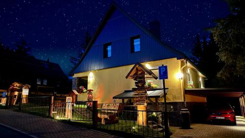 a house with a sign in front of it at night at Ferienwohnung-direkt-am-Skihang mit Sauna in Kurort Oberwiesenthal