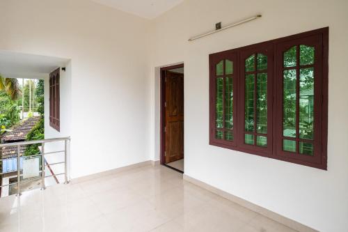 an empty room with a door and a balcony at Nest Villa - A Homely Heaven Near the Skies in Nedumbassery