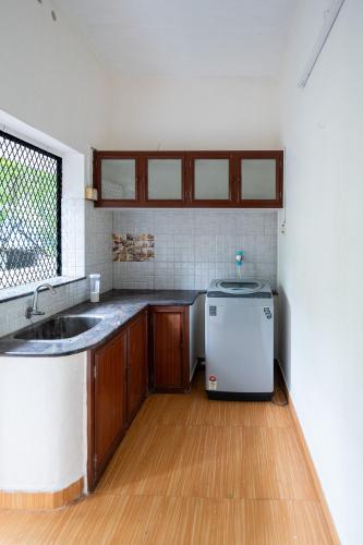 a kitchen with a sink and a refrigerator at Nest Villa - A Homely Heaven Near the Skies in Nedumbassery
