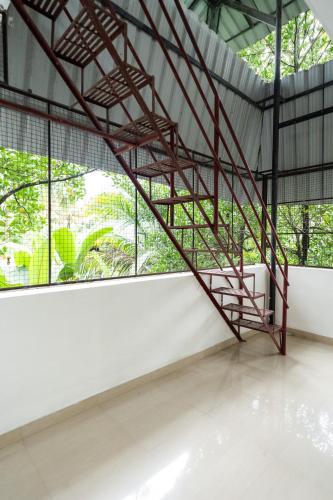 a metal staircase in a room with a window at Nest Villa - A Homely Heaven Near the Skies in Nedumbassery