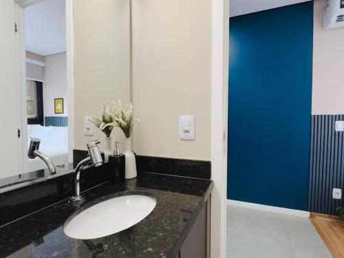 a bathroom with a sink and a blue door at Apê Paulista Augusta in São Paulo