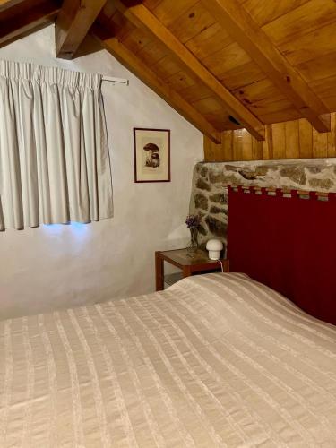 a bedroom with a bed and a window at Aveleira EcoCasa in Melgaço