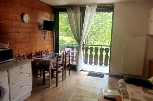 une cuisine avec une table et une grande fenêtre dans l'établissement Appartement pour 4 personnes au pied des pistes, à Châtel