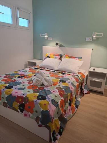 a bed with a colorful comforter in a bedroom at Estudio en Santander in Santander