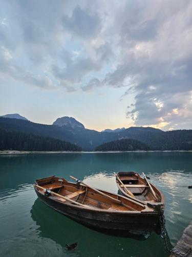 a wooden boat sitting on a body of water at Premium Apartments in Žabljak