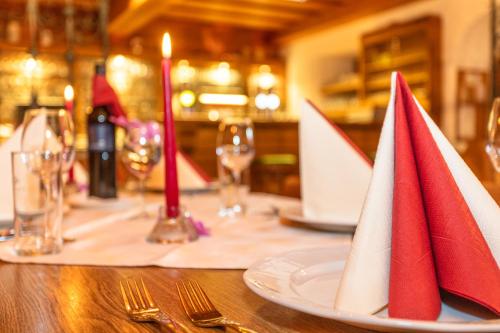 a table with a plate with red napkins and candles on it at Gasthof Maria Kirchental in Sankt Martin bei Lofer