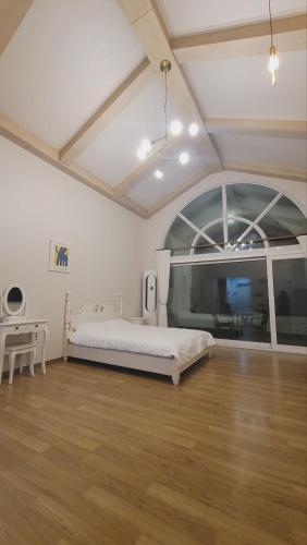 a bedroom with a bed and a desk in a room at Jennyville Pension in Seogwipo
