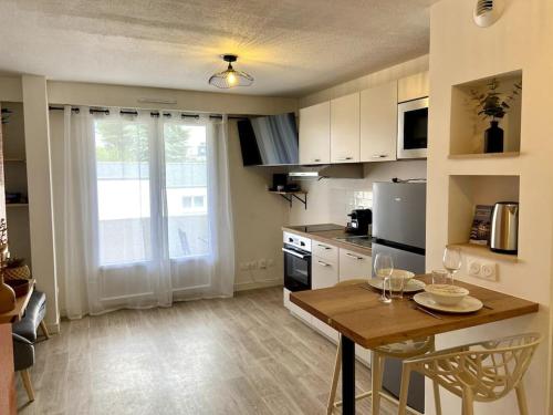 une cuisine avec une table et une salle à manger dans l'établissement Le TerraBreizh, T2 cosy et confort avec parking privé, balcon et fibre, à Lorient
