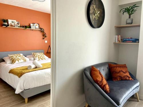 - une chambre avec un lit, un canapé et un réveil dans l'établissement Le TerraBreizh, T2 cosy et confort avec parking privé, balcon et fibre, à Lorient