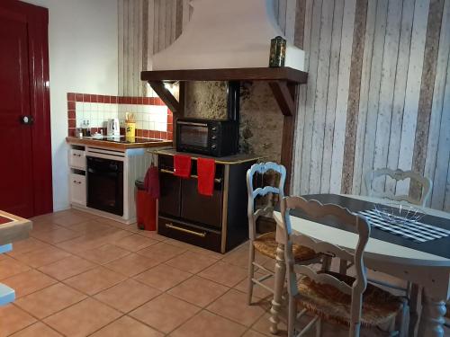une cuisine avec une table et une cuisinière four supérieur dans l'établissement L'Oostaloo Logement de vacances, à Usclas-lʼHérault