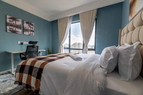 a bedroom with a large bed with a large window at Kilimani Premier 1BR in Nairobi