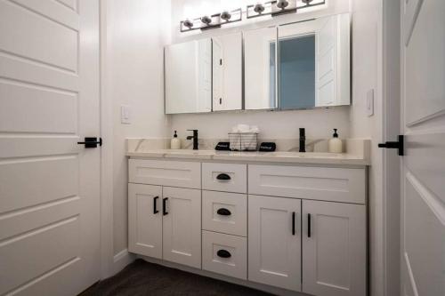 a white bathroom with a sink and a mirror at Villages Alpine Escape in Eden