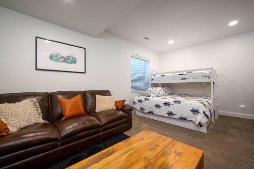 a living room with a leather couch and a bed at Villages Alpine Escape in Eden