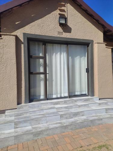 a sliding glass door on a house at Randhart guesthouse in Alberton