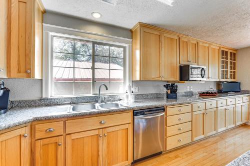 a kitchen with wooden cabinets and a window at 8 Mi to Jacksonville Oregon Getaway with Deck! in Jacksonville