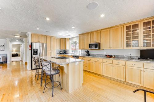 a kitchen with wooden cabinets and a kitchen island with bar stools at 8 Mi to Jacksonville Oregon Getaway with Deck! in Jacksonville