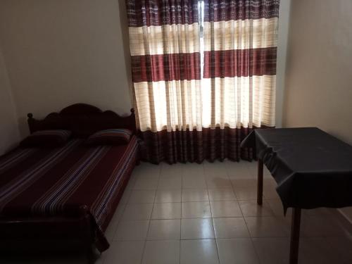 a bedroom with a bed and a window with curtains at Seven Star Guest Inn in Passara