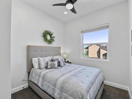 a white bedroom with a bed with a ceiling fan at Alpine Deer Hideaway in Eden