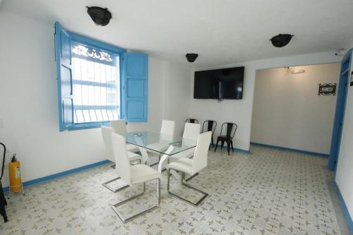 a dining room with a glass table and white chairs at Hotel Concepción Antioquia in Concepción