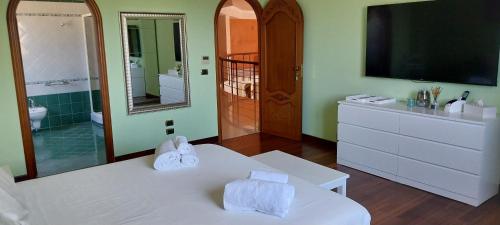 a bathroom with a white bed and a tv at Villa Giulia in Siracusa