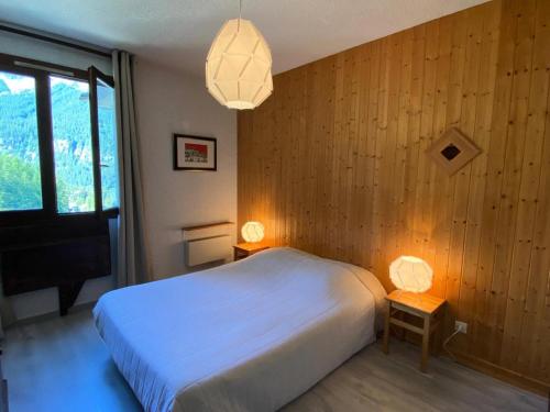 - une chambre avec un lit blanc et deux lampes dans l'établissement Résidence Les Orrianes Des ForÊts - Appartement spacieux au coeur des Orres 1650 MAE-8921, aux Orres