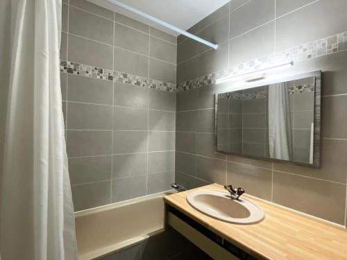 une salle de bain avec un lavabo, un miroir et une baignoire dans l'établissement Résidence Les Orrianes Des ForÊts - Appartement spacieux au coeur des Orres 1650 MAE-8921, aux Orres