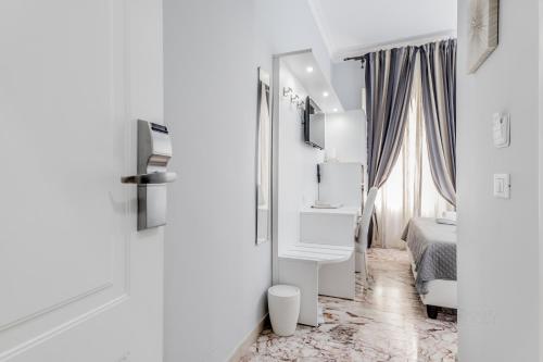 a white room with a bed and a mirror at Vatican Sweet Guest House in Rome