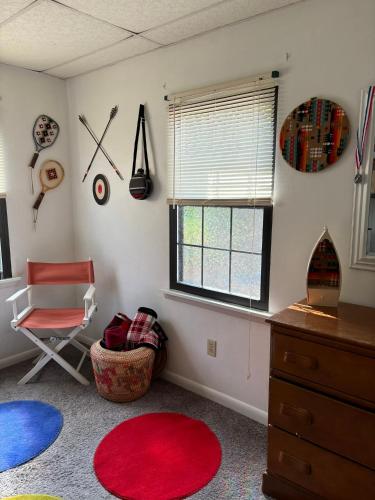 a room with a red rug and a chair and a window at Welcome to Camp Sycamore in Pittsburgh