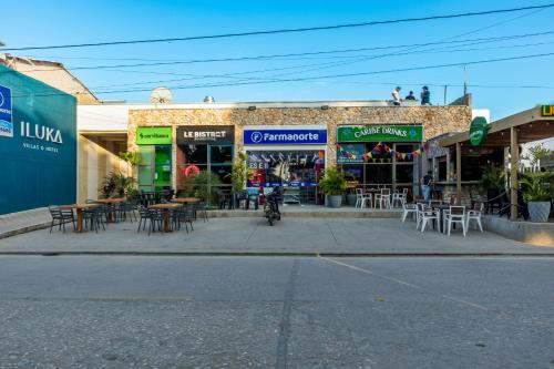 a building with tables and chairs on a street at Villa con piscina privada en coveñas sucre in Coveñas