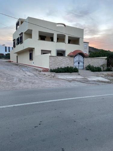 a large white building on the side of a road at Villa Ihaddadene in Nador