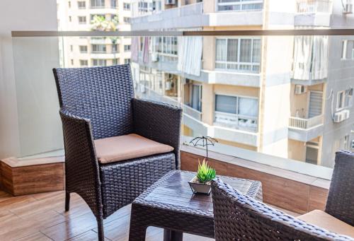 a balcony with chairs and a table and a window at Britannia Suites in Beirut