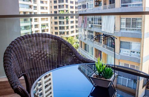 a wicker chair on a balcony with buildings at Britannia Suites in Beirut