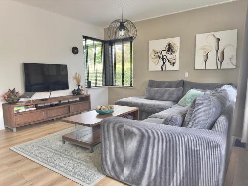 a living room with a couch and a tv at Vakantiehuis 't Hofje nabij dorpscentrum en strand in Castricum