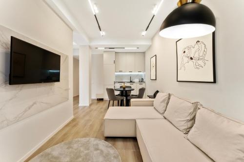 a living room with a couch and a tv on a wall at Solridge Aparthotel in Tbilisi City