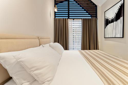 a bedroom with a white bed and a window at Solridge Aparthotel in Tbilisi City
