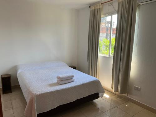 a bedroom with a bed with two towels on it at Departamento Centrico Iguazu 2B in Puerto Iguazú