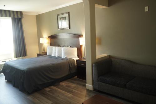 pokój hotelowy z łóżkiem i kanapą w obiekcie Harbor Inn & Suites w mieście Anaheim