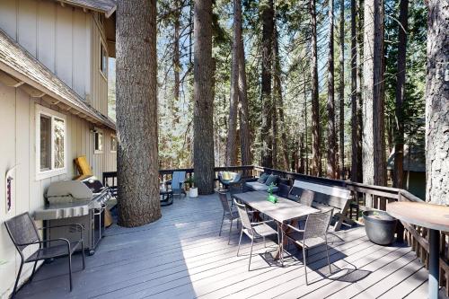 a deck with tables and chairs and trees at A Quiet Escape in Arnold