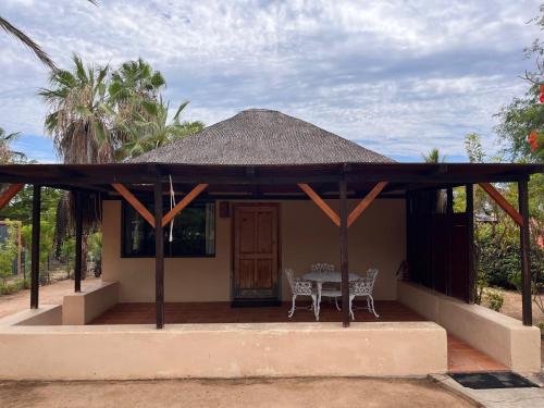 a small house with a table and a thatched roof at Cabo Pulmo Beach Resort in Cabo Pulmo