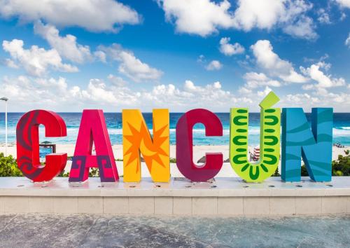 a sign for the beach with the ocean in the background at Royal lagoon room in Cancún