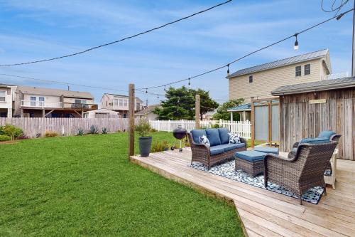 a backyard with a deck with chairs and a grill at Miller Time in Atlantic Beach
