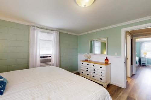 a bedroom with a bed and a dresser and a mirror at Miller Time in Atlantic Beach