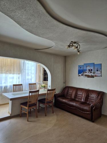a living room with a couch and a table at Wind City Apartament in Liepāja