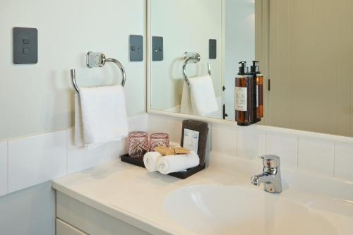 a white bathroom with a sink and a mirror at The Elmwood Motel in Christchurch