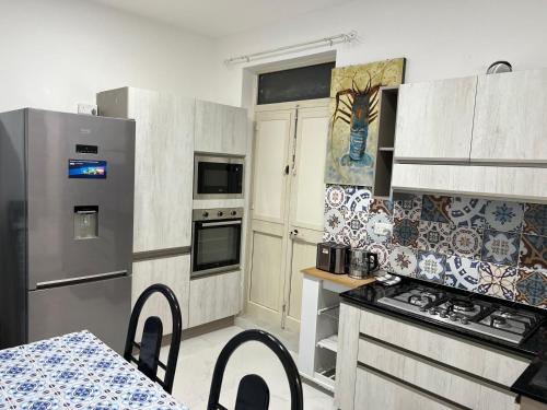 a kitchen with stainless steel appliances and a table at Sun And Sea in Santa Venera