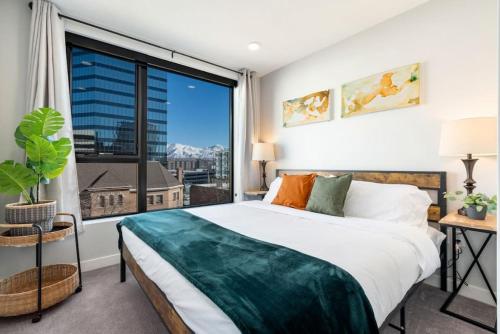 a bedroom with a bed and a large window at Modern dntwn apt- prime location in Salt Lake City