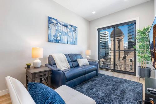 a living room with a blue couch and a window at Modern dntwn apt- prime location in Salt Lake City