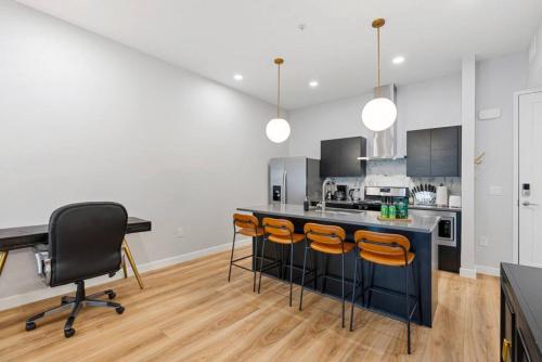 a kitchen with a black counter and orange chairs at Prime location - downtown SLC apt - ALL NEW in Salt Lake City