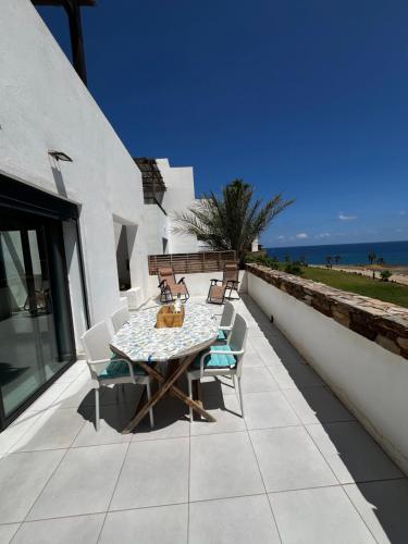 a table and chairs on a patio with the ocean at Monika Playa Macenas Mojacar in Mojácar