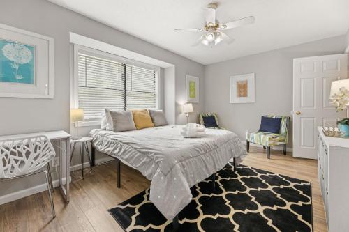 ein Schlafzimmer mit einem Bett und einem Deckenventilator in der Unterkunft Cypress Cottage in Charleston